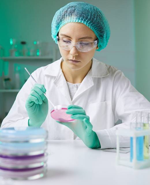 Portrait of young woman holding petri dish while working on medical research in laboratory, copy space